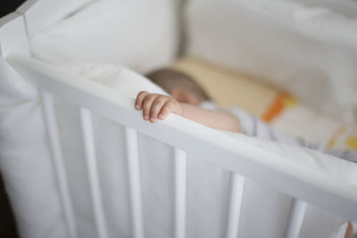 High angle close-up of child in crib at home