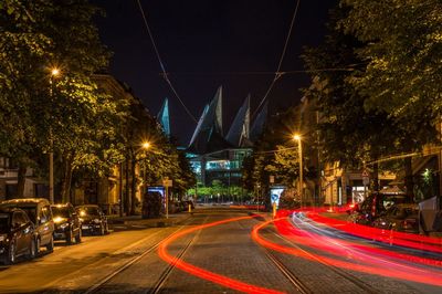 Light trails on tramway leading towards antwerp law court at night