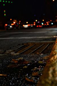 Close-up of wet car on road at night