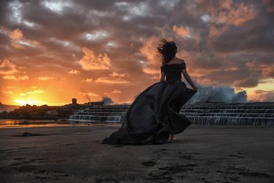 Side view of a woman statue against cloudy sky