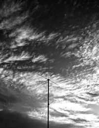 Low angle view of silhouette telephone pole against sky