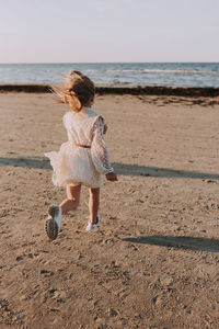 Rear view of girl on beach