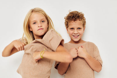 Portrait of smiling sibling against white background