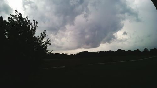 Road passing through landscape against cloudy sky