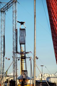 Low angle view of crane against clear blue sky