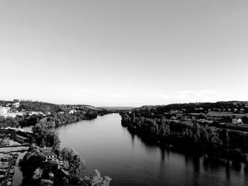 High angle view of river amidst city against clear sky