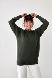 Portrait of smiling young woman against white background