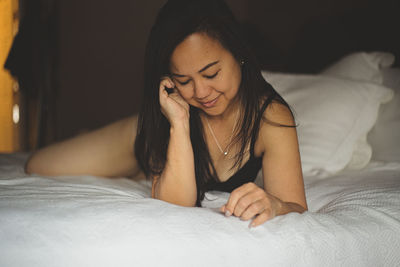 Young woman lying on bed at home