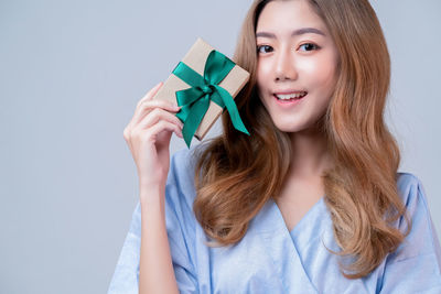 Portrait of a smiling young woman against white background