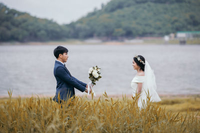 Side view of couple standing on field