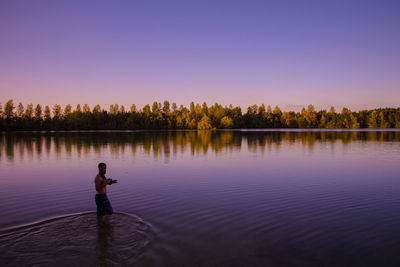Scenic view of lake against clear sky at sunset