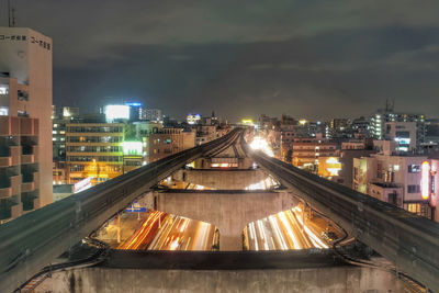 Monorail track amidst buildings at night