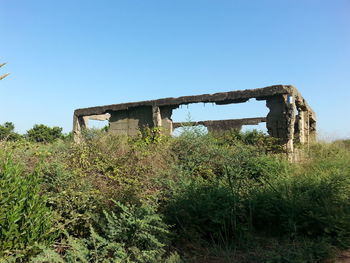 Abandoned house on field against clear sky