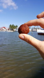 Close-up of hand holding food by river