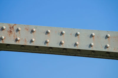 Low angle view of rusty built structure against clear blue sky