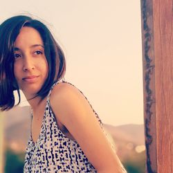 Portrait of smiling girl standing against clear sky