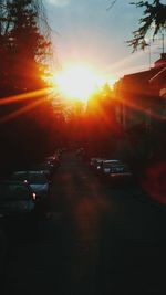 Cars on road against sky during sunset