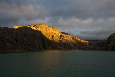 Scenic view of lake by mountains against sky