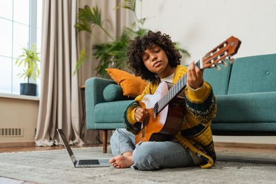 Portrait of young woman sitting on sofa at home