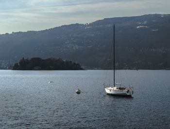 Boat sailing on lake against sky