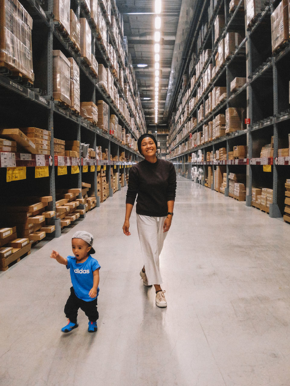 full length, childhood, child, warehouse, building, front view, architecture, males, two people, indoors, men, shelf, domestic room, boys, casual clothing, walking, portrait, standing, looking at camera, son, aisle