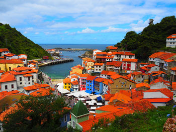 High angle view of townscape by sea against sky