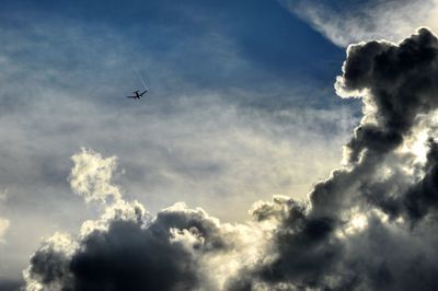 Low angle view of airplane flying against sky