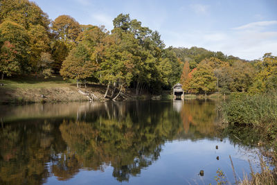 Scenic view of lake by trees against sky