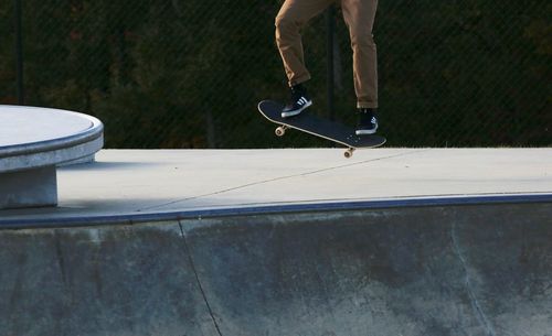 Low section of man skateboarding in park