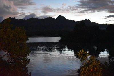 Scenic view of lake by mountains against sky