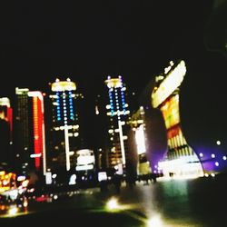 Illuminated cityscape against sky at night