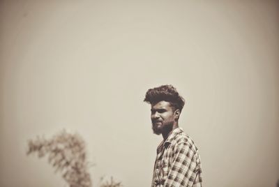 Young man standing against clear sky