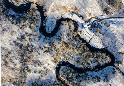 High angle view of river and houses snow covered field
