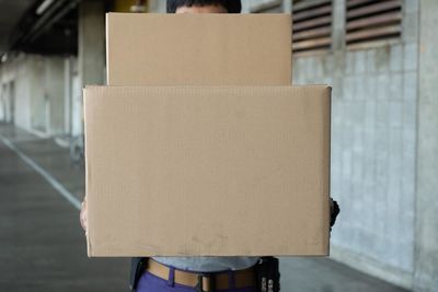 Close-up of man holding paper in box