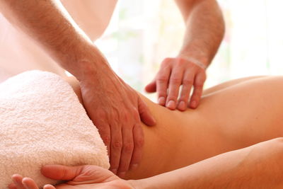 Midsection of therapist massaging woman at spa