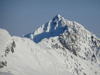 Scenic view of snowcapped mountains against clear sky