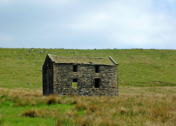 Built structure on field against sky