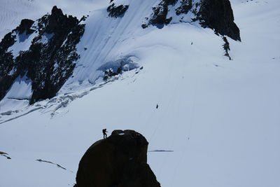 People on snowcapped mountain against sky