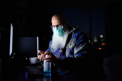 Man using smart phone while sitting in laptop