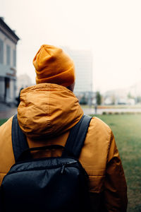 Rear view of man standing in park during winter