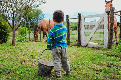 Rear view of father with son standing on land