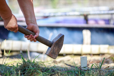 Cropped image of man hammering on field