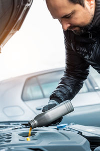 Low section of man repairing car