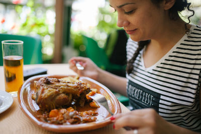Close-up of woman having food at table