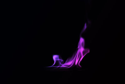 Close-up of lit candle against black background