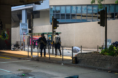 People walking on sidewalk by buildings in city
