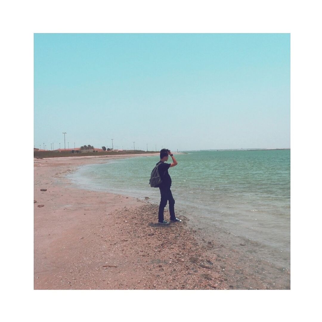 sea, standing, clear sky, real people, beach, one person, full length, water, day, outdoors, horizon over water, leisure activity, sand, nature, sky, lifestyles, vacations, men, people