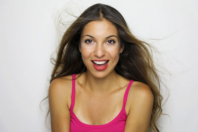 Close-up portrait of cheerful young woman against white background
