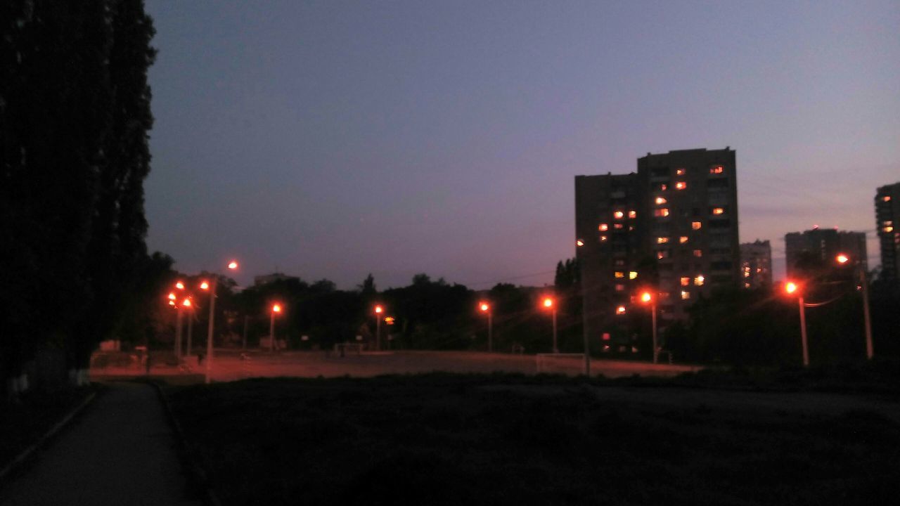 illuminated, night, building exterior, street light, clear sky, lighting equipment, street, built structure, architecture, copy space, sky, road, city, outdoors, light - natural phenomenon, dark, dusk, no people, glowing, transportation