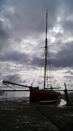 Sailboats moored in sea against sky